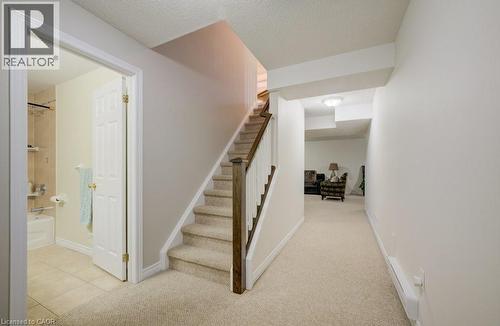 Carpeted staircase with wood-finish handrail and balusters - 7 Housler Lane, Cambridge, ON 