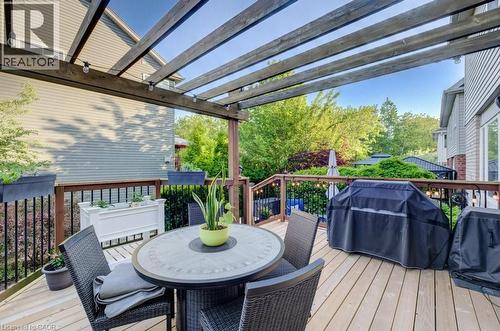 Expansive wood-finish deck featuring a slatted pergola overhead - 7 Housler Lane, Cambridge, ON 