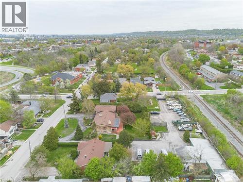 Aerial perspective showcasing a mixed-use area with residential properties, commercial lots, and a railway line - 262-270-276 Hixon Road, Hamilton, ON 