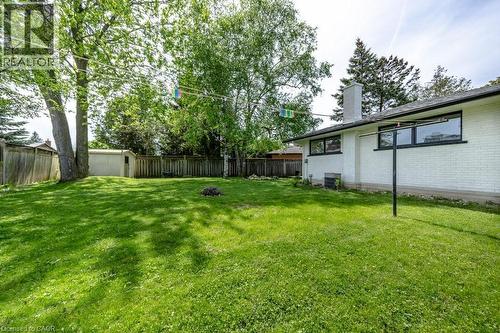 Expansive green lawn with mature trees and a white painted brick exterior - 22 Charlotte Crescent, Kitchener, ON 