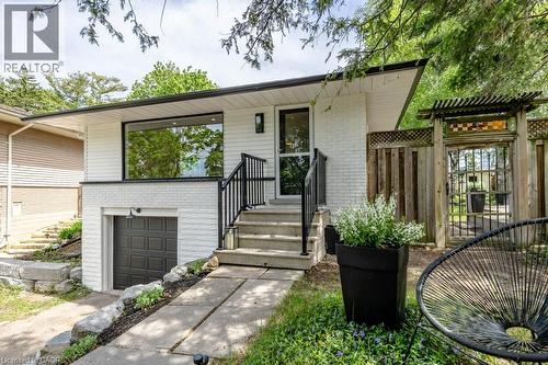 Contemporary exterior featuring white painted brick and horizontal siding - 22 Charlotte Crescent, Kitchener, ON 