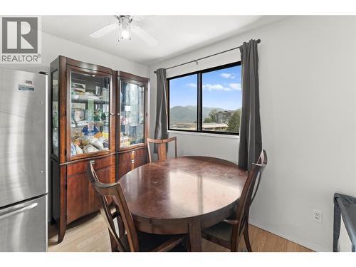 Bright dining area with large window showcasing beautiful mountain and city views, creating the perfect space to enjoy meals with natural light. - 555 Dalgleish Drive Unit# 412, Kamloops, BC - Indoor Photo Showing Dining Room