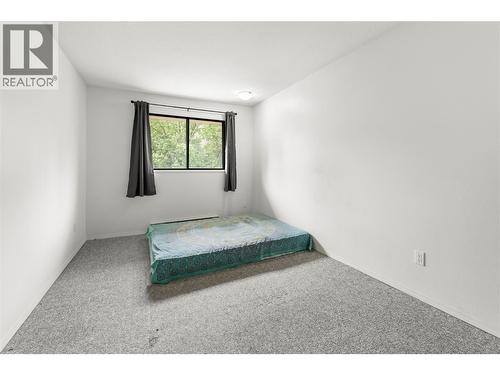 Generous secondary bedroom with large window, soft natural light, and flexible space ideal for guests, family, or a home office setup. - 555 Dalgleish Drive Unit# 412, Kamloops, BC - Indoor