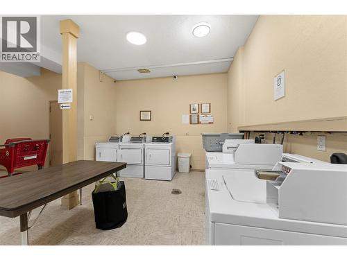 Shared laundry facility conveniently located within the building, offering multiple washers and dryers for residents’ everyday convenience. - 555 Dalgleish Drive Unit# 412, Kamloops, BC - Indoor Photo Showing Laundry Room