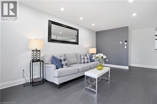 Living area featuring recessed lighting, a statement accent wall, white baseboards, and dark wood-finish flooring - 7 Upper Mercer Street Unit# G30, Kitchener, ON - Indoor Photo Showing Living Room