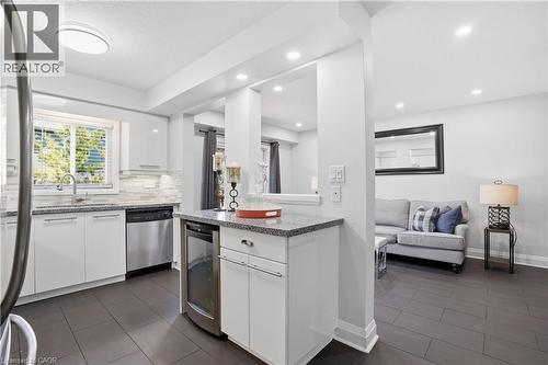 Kitchen featuring white cabinetry, stainless steel appliances, granite countertops, and a tile backsplash - 7 Upper Mercer Street Unit# G30, Kitchener, ON - Indoor Photo Showing Kitchen With Upgraded Kitchen