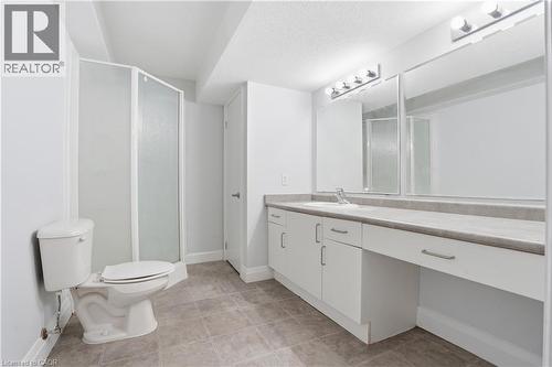 Bathroom featuring a white vanity with integrated sink, expansive countertop, and chrome fixtures - 7 Upper Mercer Street Unit# G30, Kitchener, ON - Indoor Photo Showing Bathroom