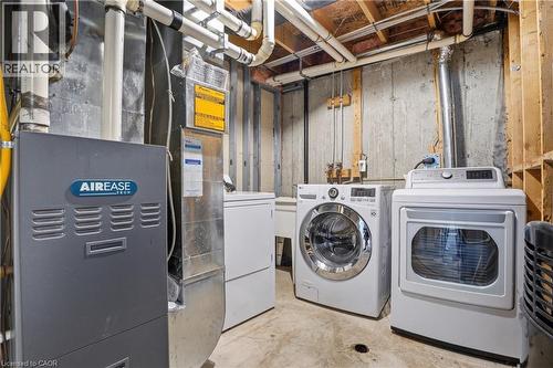 Dedicated laundry area featuring a front-load washer, a front-load dryer, and a utility sink - 7 Upper Mercer Street Unit# G30, Kitchener, ON - Indoor Photo Showing Laundry Room