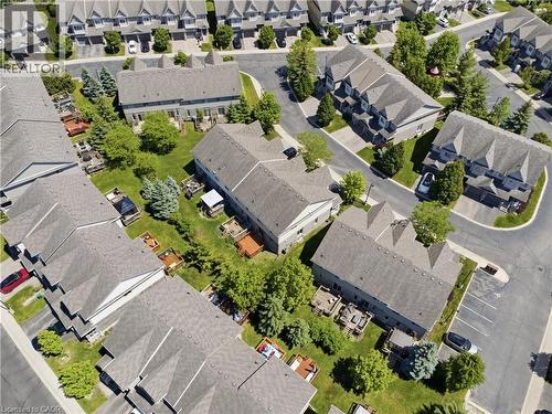 Aerial overview of a residential community featuring multiple multi-story buildings with grey shingle roofs - 7 Upper Mercer Street Unit# G30, Kitchener, ON - Outdoor With View