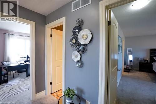 Hallway featuring light gray walls, white trim, and light gray carpet - 365 Poldon Drive, Norwich, ON 