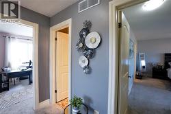 Hallway featuring light gray walls, white trim, and light gray carpet - 