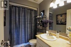 Bathroom with a vanity featuring an oval sink and a light-colored countertop - 