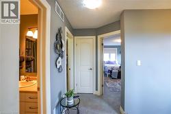 Hallway featuring carpet flooring, overhead lighting, and white trim - 