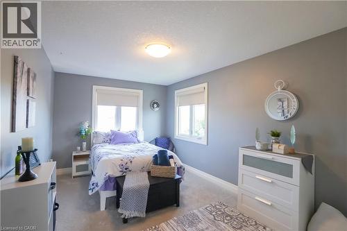 Carpeted room with two windows featuring roller shades, painted walls, and white trim - 365 Poldon Drive, Norwich, ON 