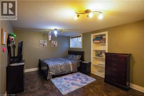 Room featuring wood-finish flooring, a built-in shelving unit, and a window with white trim - 365 Poldon Drive, Norwich, ON 