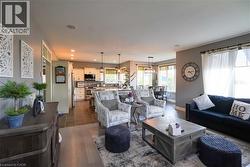 Living area featuring wood-finish flooring, recessed lighting, and a window with white drapery - 