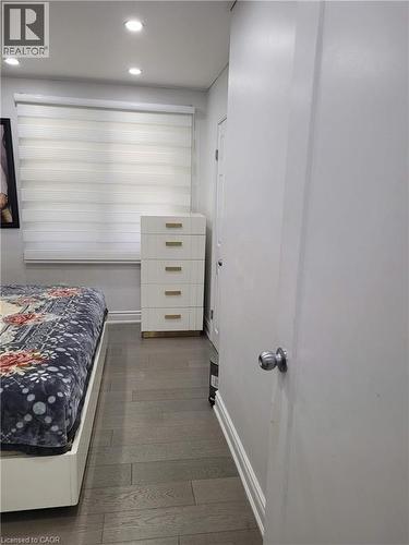 Room featuring wood-finish flooring, recessed lighting, and a window with horizontal blinds - 153 Arnold Street, Kitchener, ON 