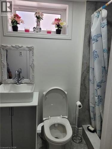 Bathroom featuring a contemporary vessel sink with a chrome faucet, a toilet with an attached bidet, and a shower with a tiled surround - 153 Arnold Street, Kitchener, ON 