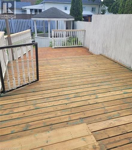 Expansive wood deck with a built-in white gazebo, white spindle railings, and surrounding privacy fencing - 153 Arnold Street, Kitchener, ON 