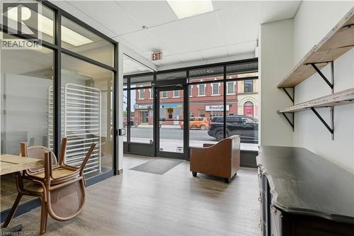 Interior retail space featuring front-facing glass storefront, wood-finish flooring, and recessed lighting - 389 Dundas Street, Woodstock, ON 