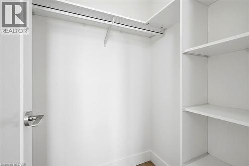 Walk-in closet featuring white built-in shelving, a hanging rod, and baseboard trim - 7 Mabelle Avenue Unit# Ph07, Toronto, ON 