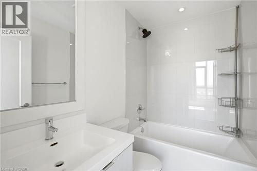 Contemporary bathroom featuring a white vanity with integrated sink, chrome faucet, a framed wall mirror, and a white bathtub with subway-tiled surround - 7 Mabelle Avenue Unit# Ph07, Toronto, ON 