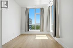 Bright room featuring expansive windows, wood-finish flooring, white walls, and contemporary window treatments - 
