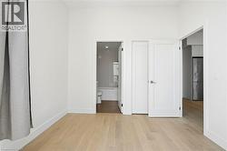Light wood-finish flooring complements crisp white walls and baseboards - 