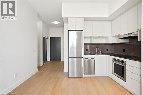 Modern kitchen featuring white cabinetry, stainless steel appliances, dark stone countertops, and a subway tile backsplash - 7 Mabelle Avenue Unit# Ph07, Toronto, ON 