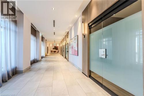 Long hallway featuring neutral-toned tile flooring, recessed lighting, and frosted glass doors - 7 Mabelle Avenue Unit# Ph07, Toronto, ON 
