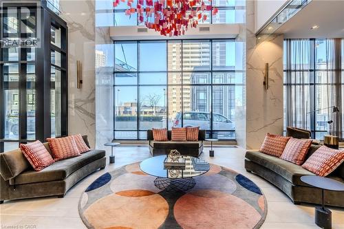 Grand lobby space featuring a striking red and orange geometric chandelier, floor-to-ceiling windows, and polished marble wall accents - 7 Mabelle Avenue Unit# Ph07, Toronto, ON 