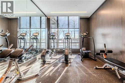 Fitness center featuring floor-to-ceiling windows, wood-finish wall panels, recessed lighting, and resilient flooring - 7 Mabelle Avenue Unit# Ph07, Toronto, ON 
