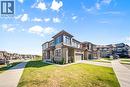 View of front of house featuring a residential view, concrete driveway, a front lawn, brick siding, and a garage - 1 Bee Crescent, Brantford, ON 