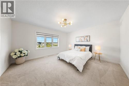 Bedroom featuring light colored carpet and a chandelier - 1 Bee Crescent, Brantford, ON 