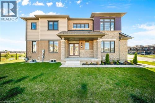 Rear view of property featuring covered porch, a yard, brick siding, and french doors - 1 Bee Crescent, Brantford, ON 