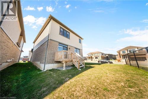 Rear view of property with brick siding, a lawn, and a residential view - 1 Bee Crescent, Brantford, ON 