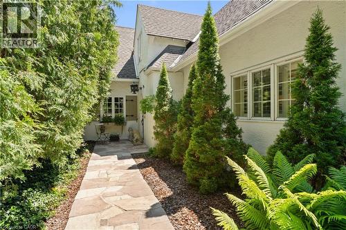 Flagstone walkway to front door. Cedar privacy hedge. Antique exterior coach lights. - 3040 First Street, Burlington, ON - Indoor Photo Showing Other Room