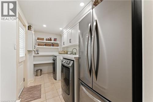 Frigidare fridge, washer, dryer. Gravelle white shaker cabinetry. Quartz countertop. Deep sink with Kohler handspray. Main floor. Side door. Adjoins mudroom. - 3040 First Street, Burlington, ON - Outdoor With In Ground Pool