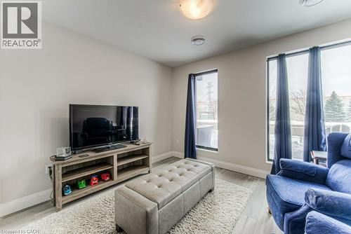 Recessed lighting illuminates this room featuring light-toned walls and wood-finish flooring - 5 Wake Robin Drive Unit# 107, Kitchener, ON 