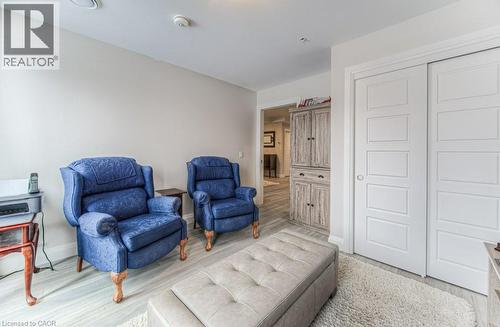 Light-toned wood-finish flooring extending into the hallway, complemented by a textured area rug - 5 Wake Robin Drive Unit# 107, Kitchener, ON 