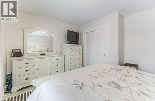 Bedroom featuring light-toned walls and wood-finish flooring - 5 Wake Robin Drive Unit# 107, Kitchener, ON 