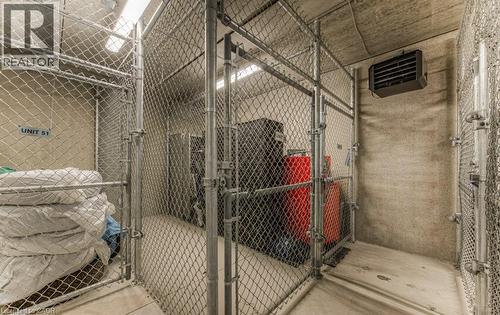 Individual storage unit featuring chain-link fencing, concrete walls, concrete flooring, and an overhead lighting fixture - 5 Wake Robin Drive Unit# 107, Kitchener, ON 
