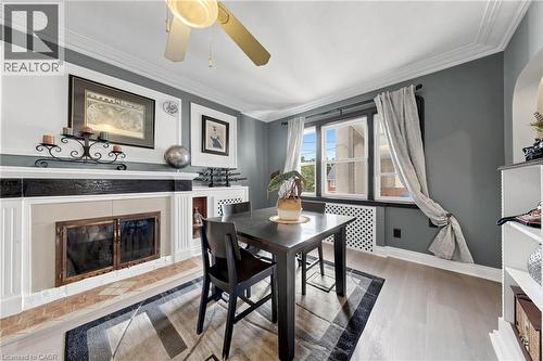 Formal living space featuring crown molding, a decorative fireplace with a stone surround, and light wood-finish flooring - 287 Courtland Avenue E, Kitchener, ON 