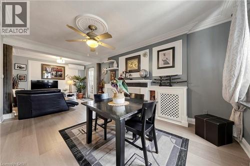 Open-concept living and dining area featuring light wood-finish flooring, a decorative ceiling medallion with a fan light fixture, and crown molding - 287 Courtland Avenue E, Kitchener, ON 