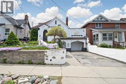 White stucco exterior with an arched entryway, integrated single-car garage, and a sloped driveway - 