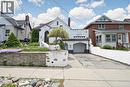 White stucco exterior with an arched entryway, integrated single-car garage, and a sloped driveway - 287 Courtland Avenue E, Kitchener, ON 
