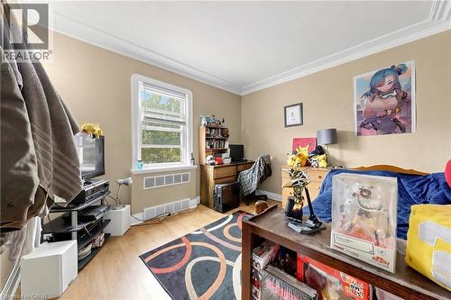 Room featuring wood-finish flooring, a double window, crown molding, and neutral wall tones - 287 Courtland Avenue E, Kitchener, ON 