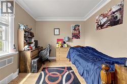 Room featuring neutral-toned walls, crown molding, and wood-finish flooring - 