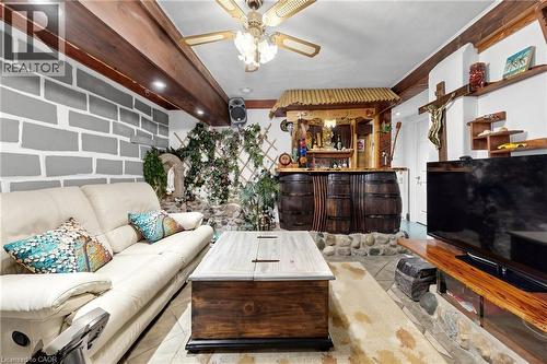 Entertainment room featuring exposed wood beams, recessed lighting, and a distinctive bar crafted from barrel sections set on a stone base - 287 Courtland Avenue E, Kitchener, ON 