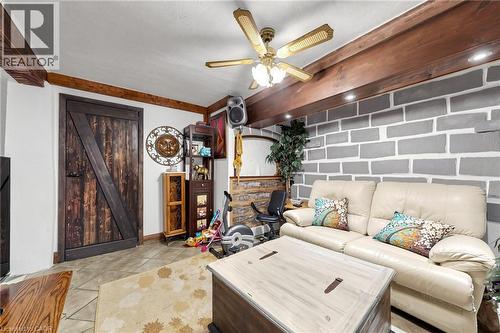 Reclaimed wood-finish door with diagonal bracing, exposed wood ceiling beams, decorative wall paneling, recessed lighting, and a ceiling fan with integrated lighting - 287 Courtland Avenue E, Kitchener, ON 